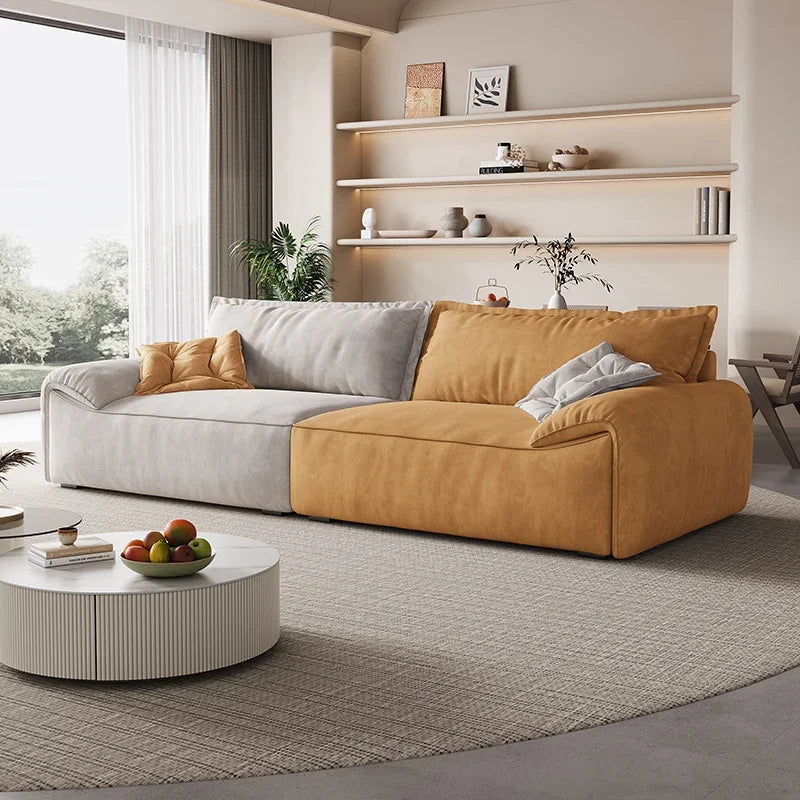 Modern living room with a yellow and gray sectional sofa, round coffee table, and decorative items.