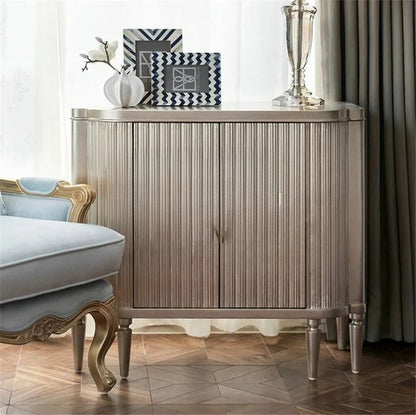 Decorative sideboard with a lamp and framed pictures in a room setting.