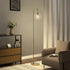 Modern living room with a floor lamp, sofa, and side table.