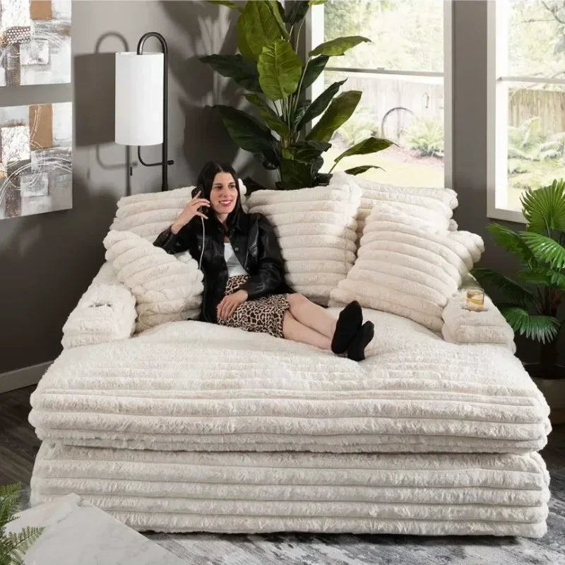 Person sitting on a large, fluffy white sofa in a modern living room.