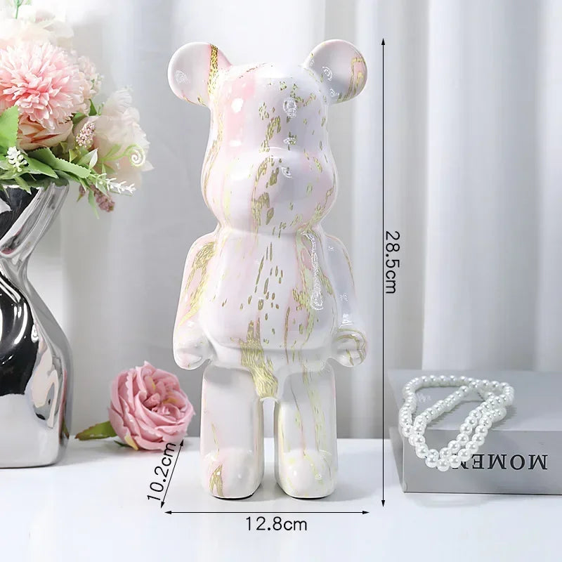 Decorative bear figure with measurements on a white surface with flowers and jewelry.