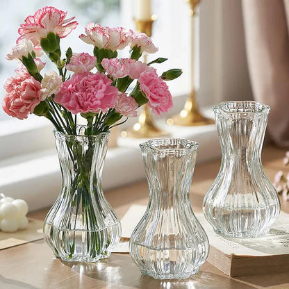 Clear glass vases with pink flowers on a table