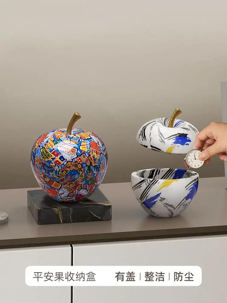 A side view of the apple decor on a foyer console table with keys inside.