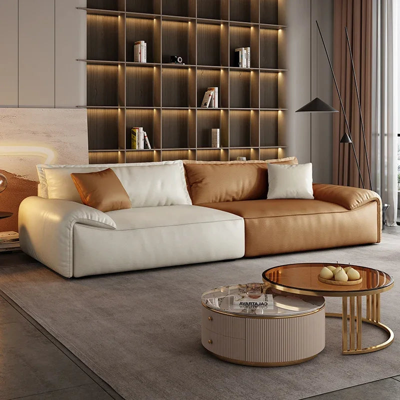 Modern living room with a brown and white sofa, coffee tables, and a bookshelf.