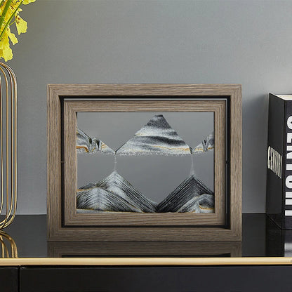 Framed artwork of mountains on a shelf with decorative items.