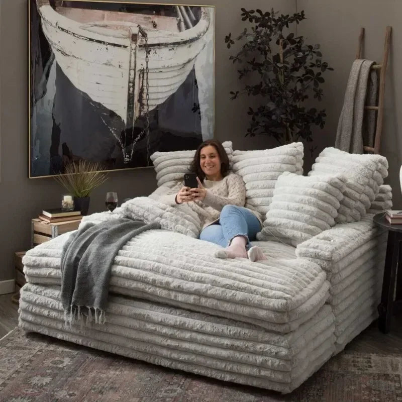 Woman sitting on a large, fluffy sofa in a cozy living room.