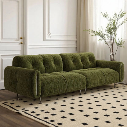 Green sofa in a room with a patterned rug and decorative elements.