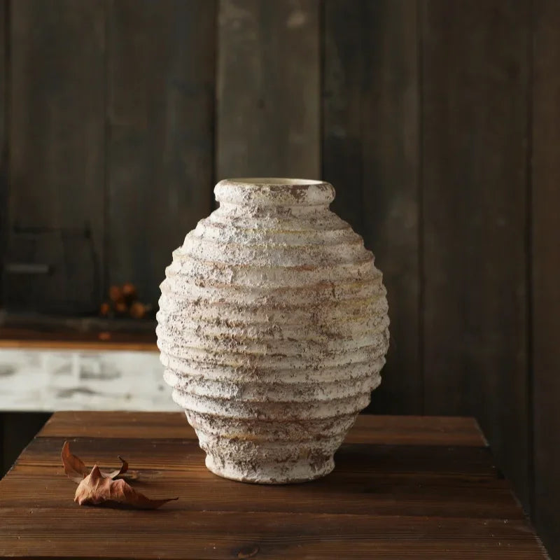 Textured ceramic vase on a wooden surface with a blurred background