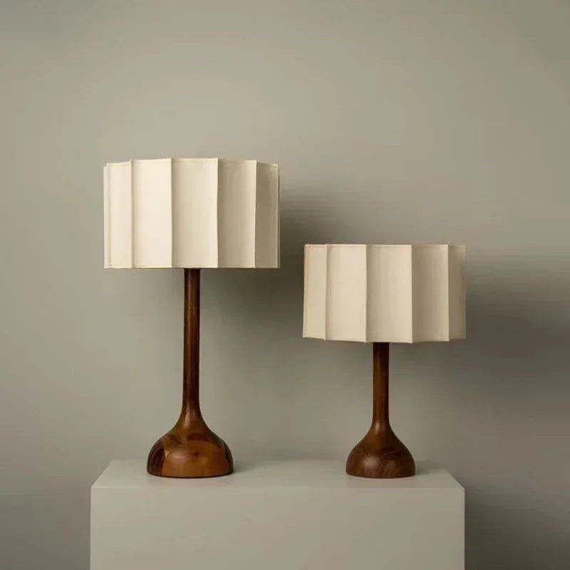 Two table lamps with wooden bases and beige lampshades on a neutral background