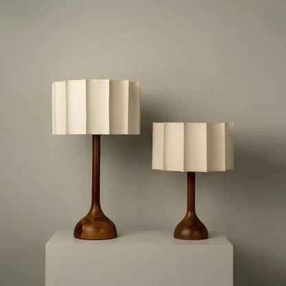 Two table lamps with wooden bases and beige lampshades on a neutral background