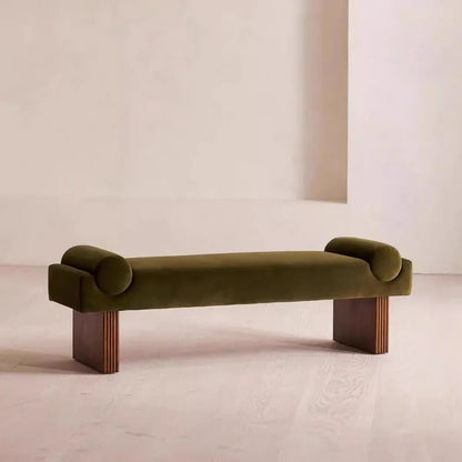 Green velvet bench with wooden legs on a neutral background