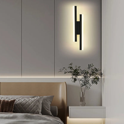 Modern wall sconce above a bed in a bedroom setting