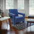 Blue armchair in a room with wooden floor and large windows