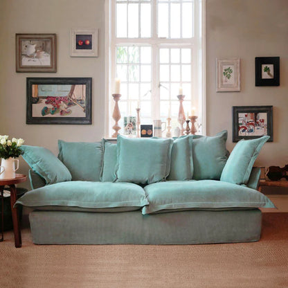 Turquoise sofa in a living room with framed pictures on the wall.