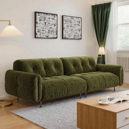 Green sofa in a living room with a wooden coffee table and decorative elements.