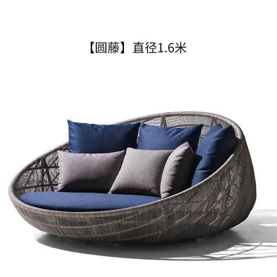 Cozy outdoor garden round bed chair with a throw blanket.