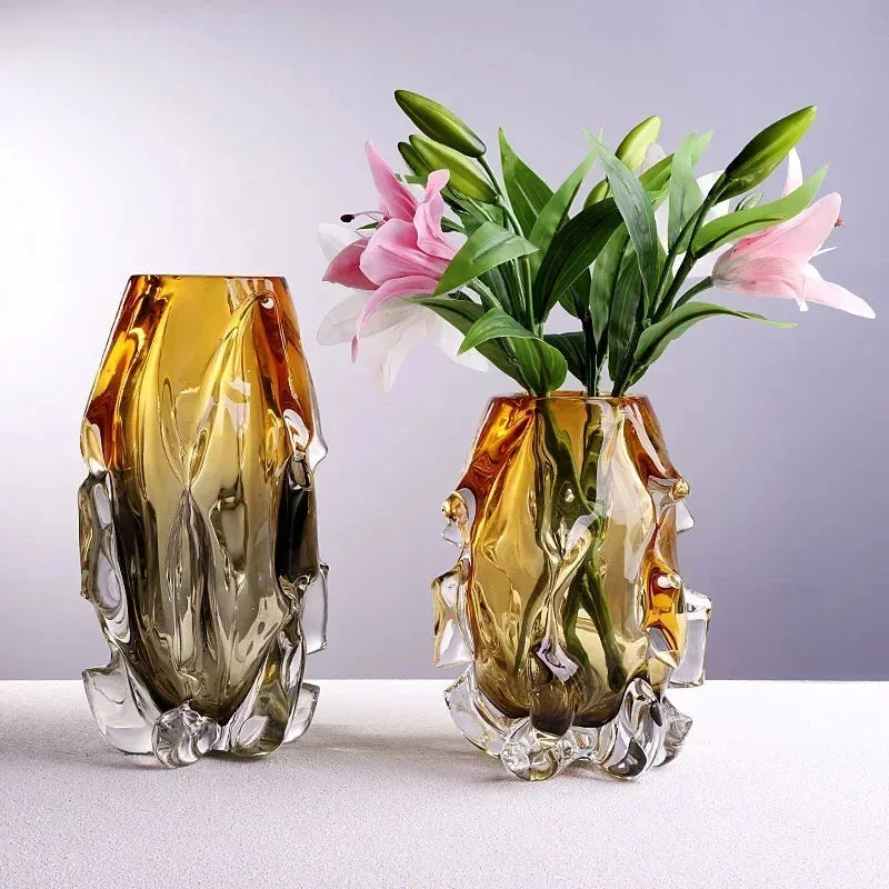 Two decorative glass vases with floral arrangements on a light background
