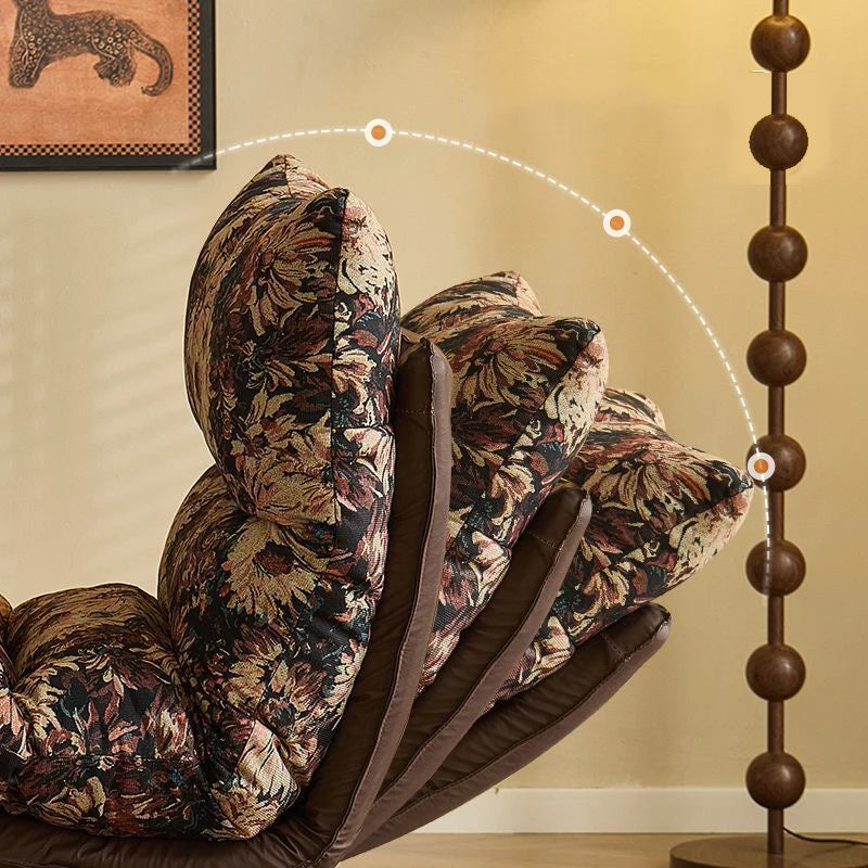 Floral-patterned cushions on a brown chair against a beige wall.