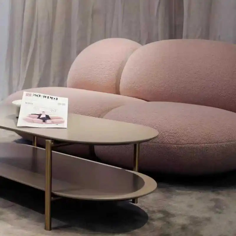 Modern pink sofa with a coffee table and magazine in a living room setting.