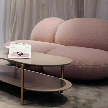 Modern pink sofa with a coffee table and magazine in a living room setting.