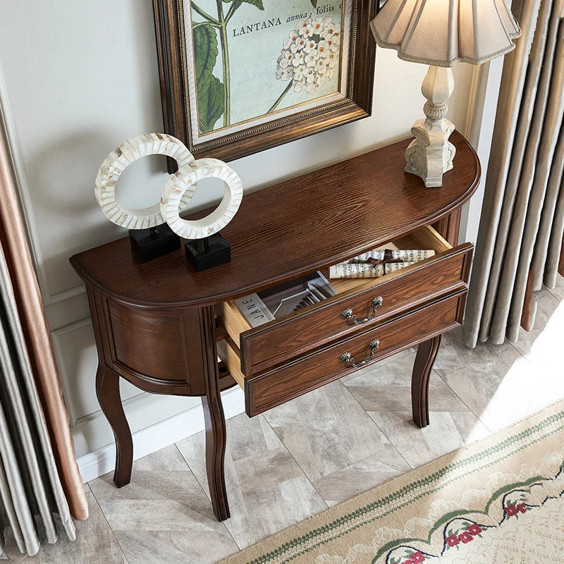 Wooden console table with a lamp and decor items in a room setting.