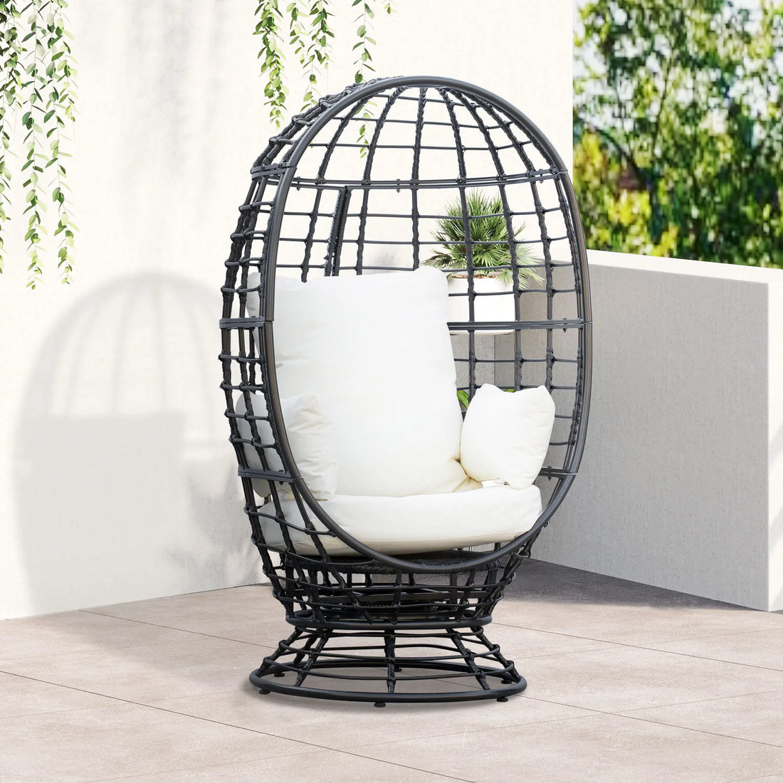 Black egg-shaped chair with white cushions on a wooden deck