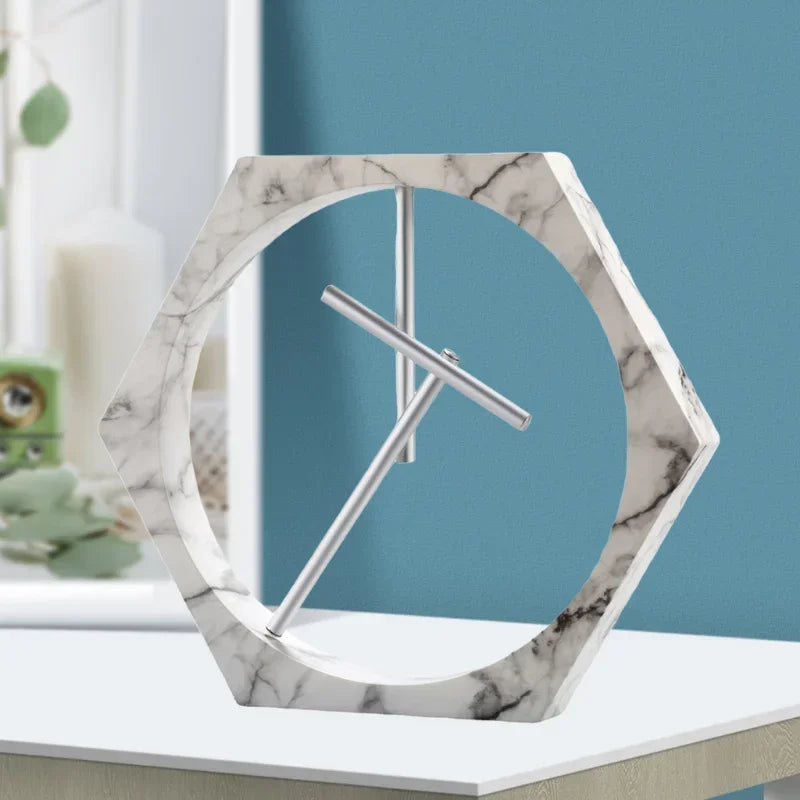 Marble-patterned hexagonal clock on a white surface with a blue wall background