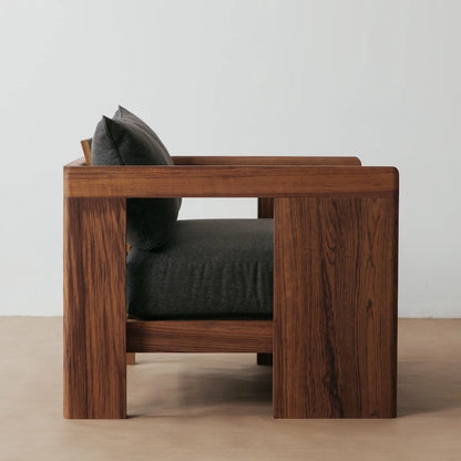 Wooden armchair with dark cushions on a neutral background
