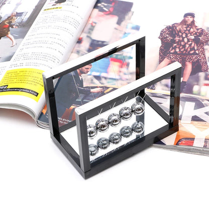 Black glass display case with small round objects on a magazine background