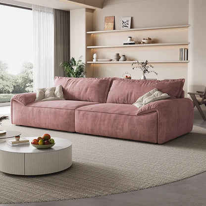 Pink sofa in a modern living room with shelves and a round coffee table.