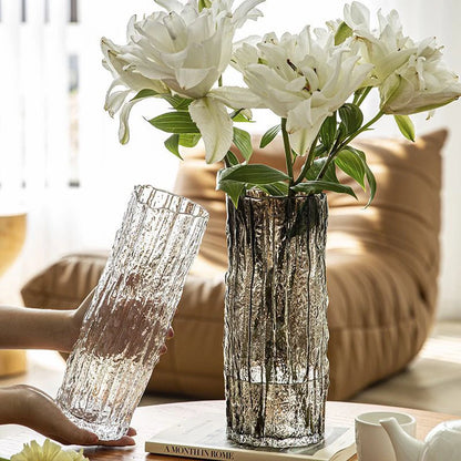 Two decorative vases with white flowers on a table in a living room setting.