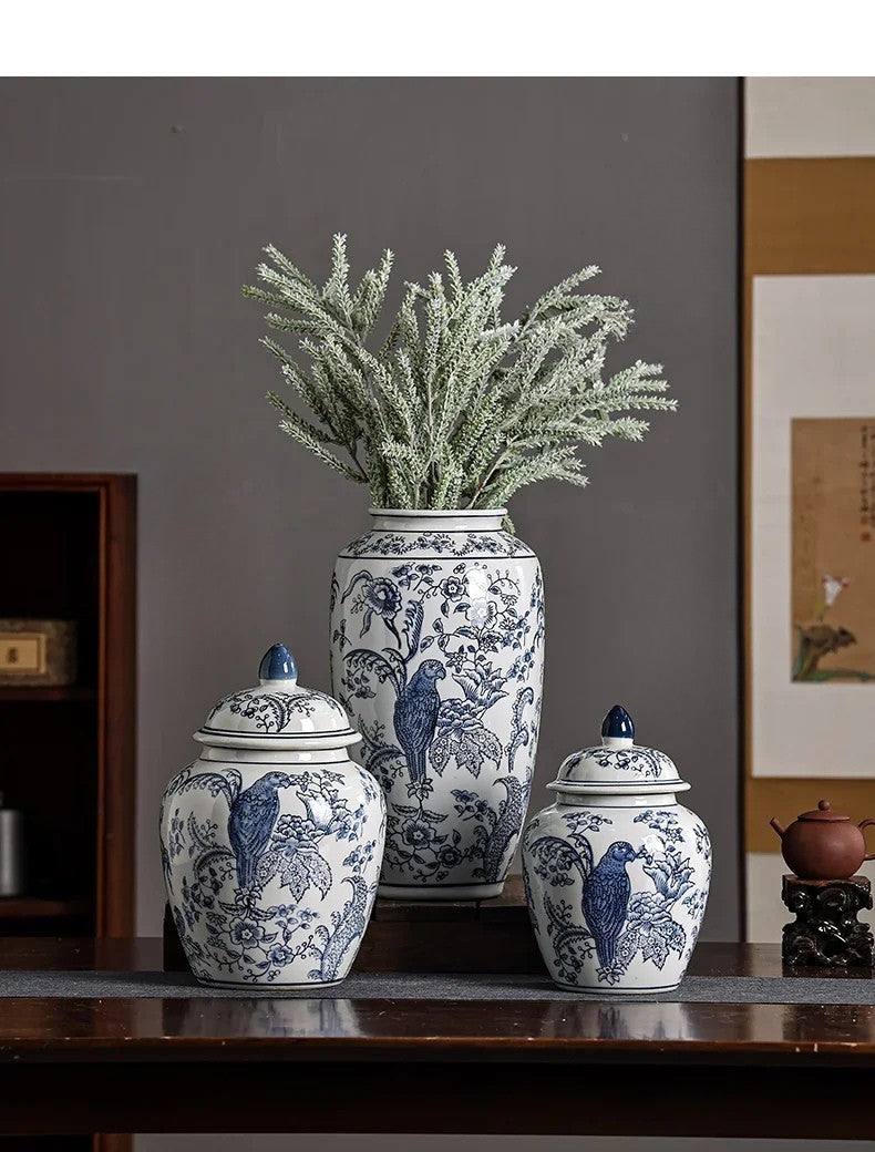 Set of three blue and white ceramic jars with floral and bird patterns on a wooden surface.