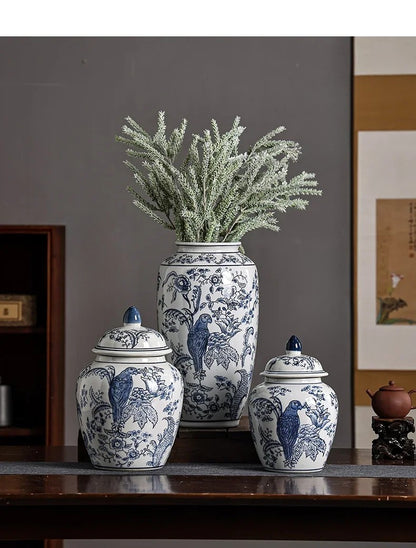 Set of three blue and white ceramic jars with floral and bird patterns on a wooden surface.