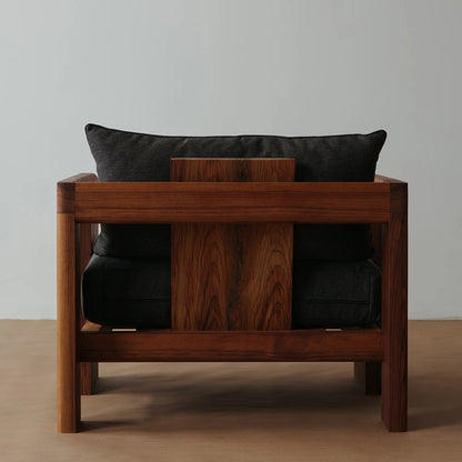 Wooden bench with black cushions on a plain background