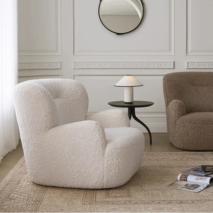 Two armchairs in a room with a side table and mirror on the wall.