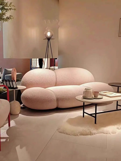 Modern living room with a pink sofa and decorative items.