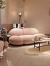 Modern living room with a pink sofa and decorative items.