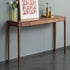 Wooden console table against a gray wall with decorative items on top