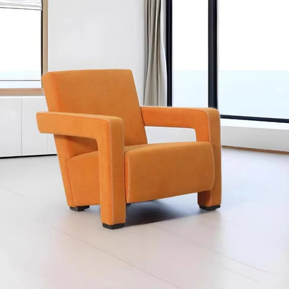 Orange armchair in a modern room with large windows.