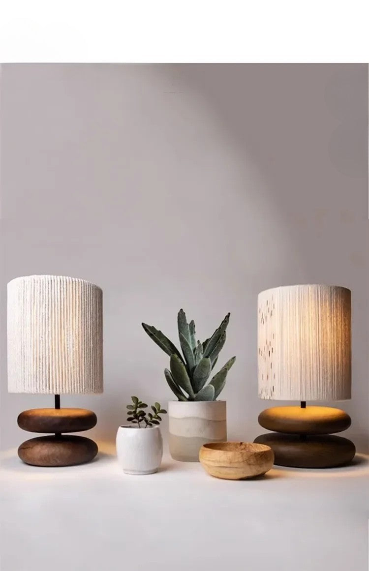 Two wooden table lamps with striped lampshades on a light surface with a neutral background