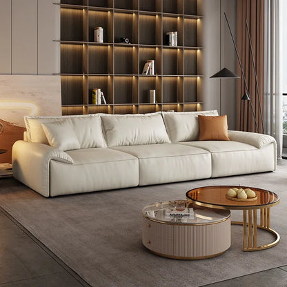 Modern living room with a beige sofa, coffee table, and bookshelf.