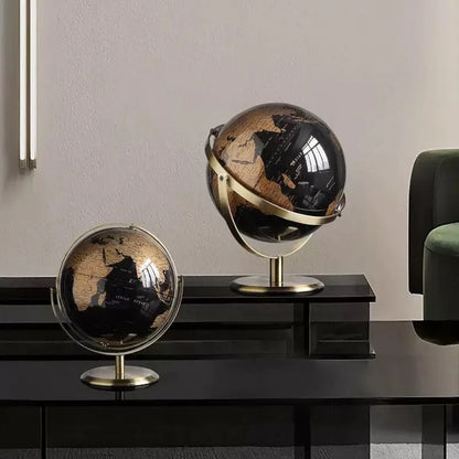 Two decorative globes on a dark surface with a neutral background