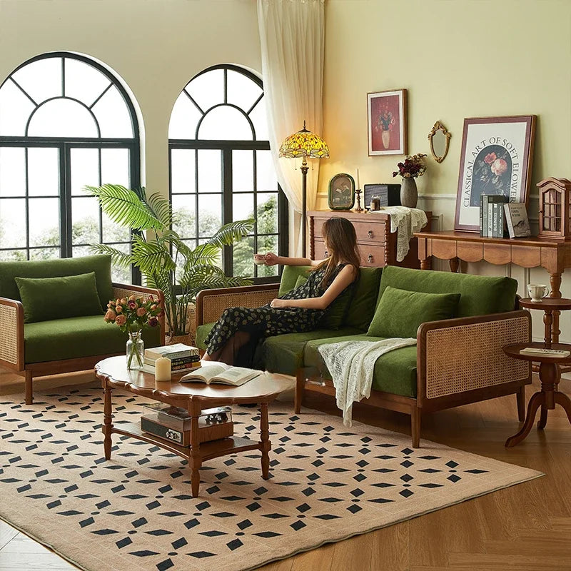 Woman sitting on a green sofa in a stylish living room with decor elements.