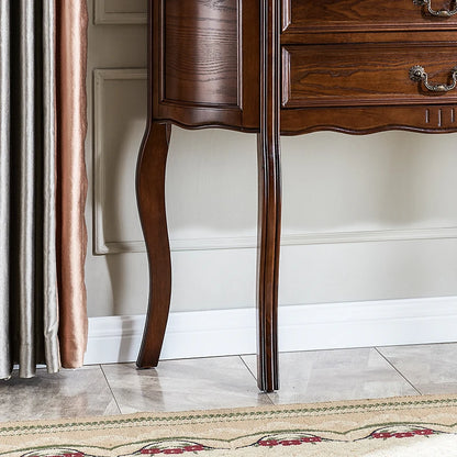 Wooden sideboard with elegant legs against a neutral wall.
