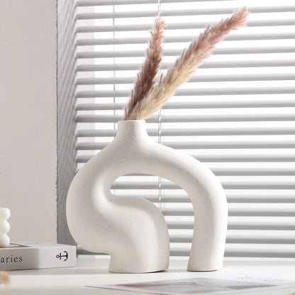 White ceramic vase with dried pampas grass against a window with blinds