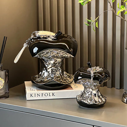 Decorative black and silver lampshades on a surface with a book titled &