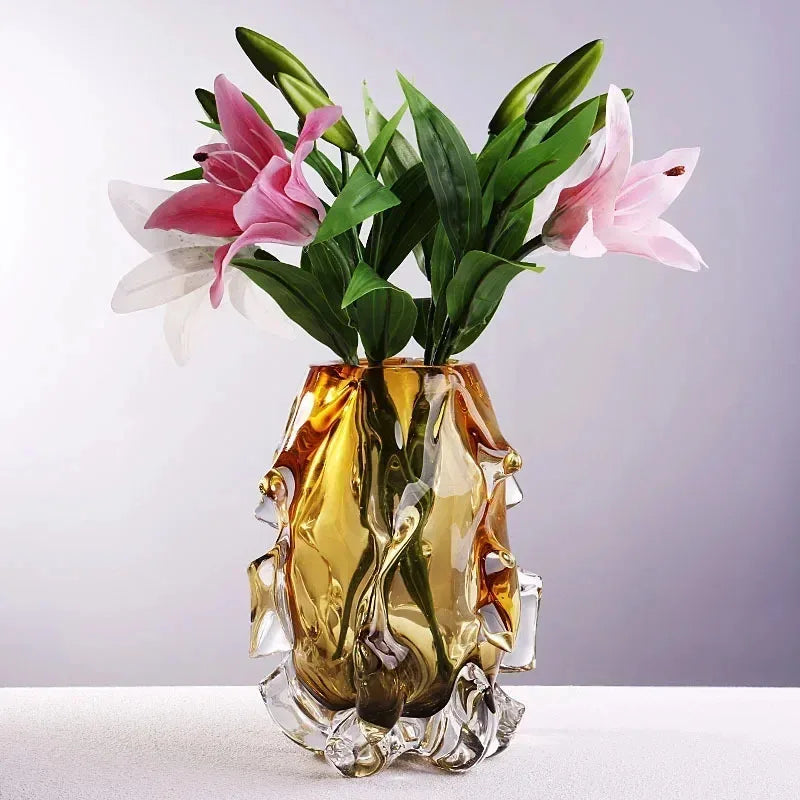 Glass vase with pink lilies and green leaves on a white background