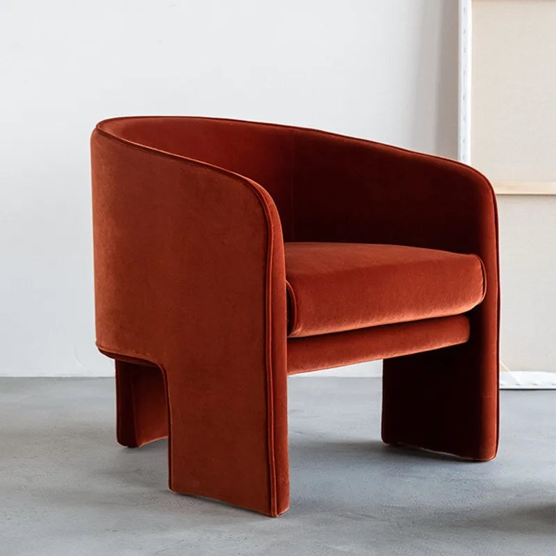 Red velvet armchair on a light gray floor with a white wall background