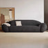 Modern black sofa with white cushions in a minimalistic room.