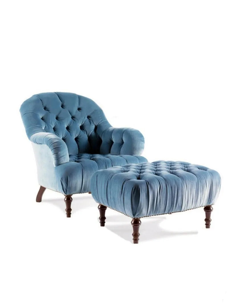 Blue velvet armchair with matching ottoman on a white background